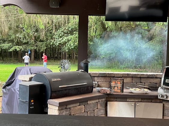 outdoor grilling space with golfers in the background